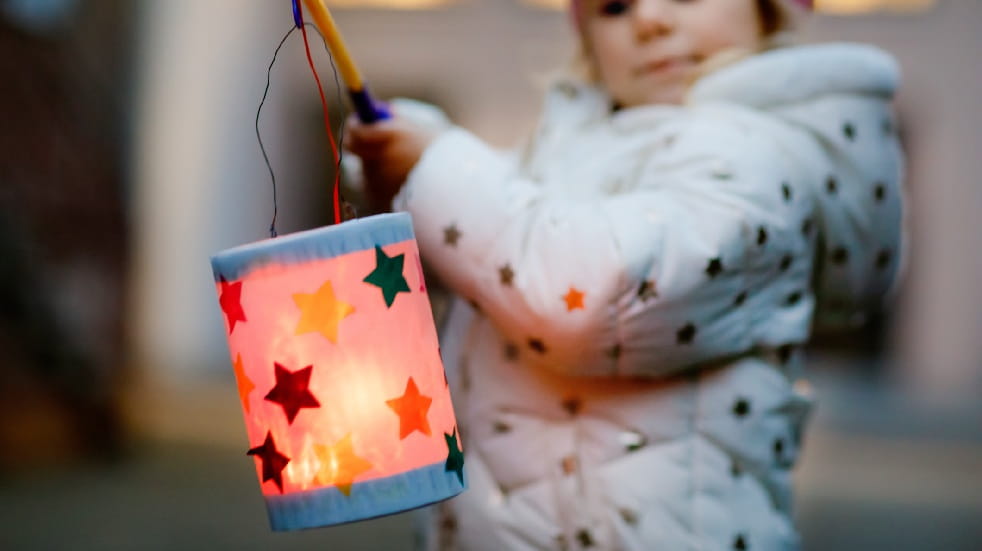 girl holding christmas lantern on string